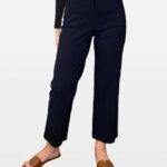 Navy cropped trousers paired with a black top and brown slide sandals.