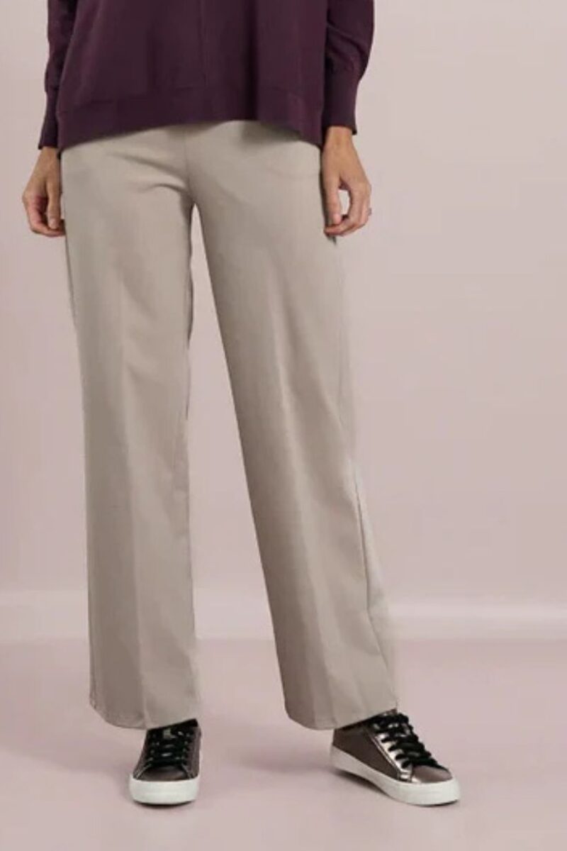 Person wearing light gray wide-leg pants with a dark burgundy top and brown sneakers with white soles, shown from the waist down.