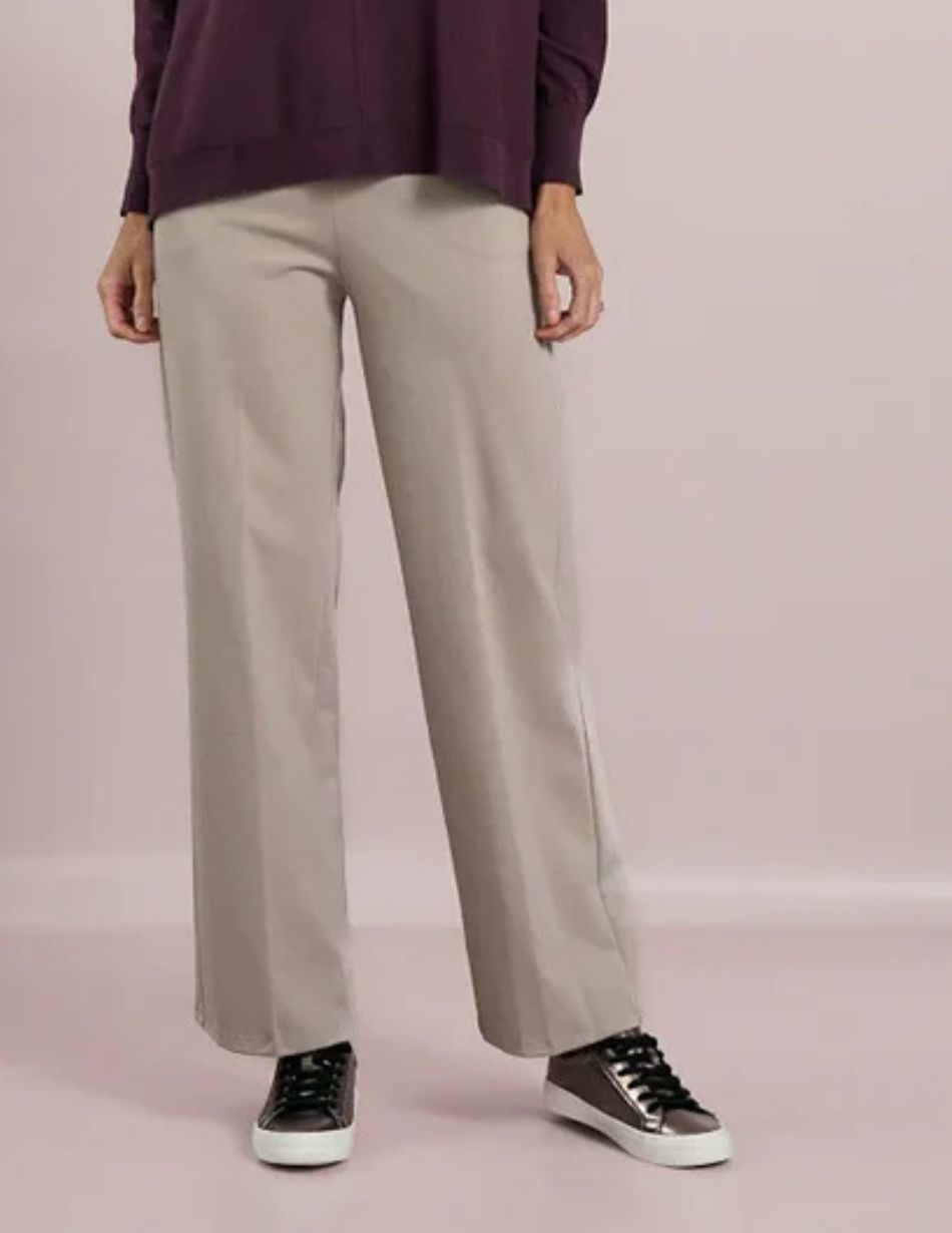 Person wearing light gray wide-leg pants with a dark burgundy top and brown sneakers with white soles, shown from the waist down.