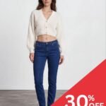 Model wearing a cream cropped knit cardigan and blue jeans in a studio; red promotional overlay reads '30% OFF' in the corner