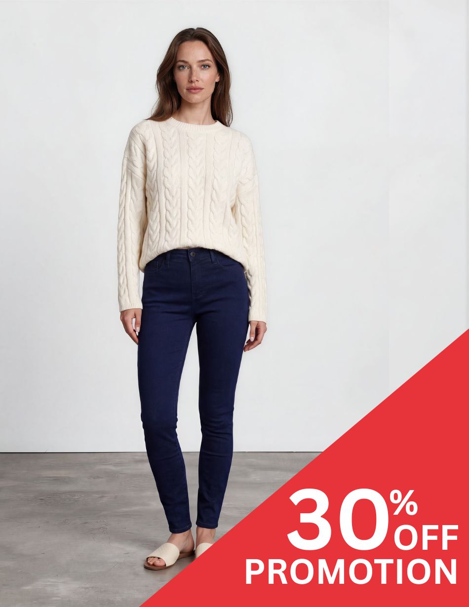 SHERI SLIM QUINN DIS Woman in a cream cable-knit sweater and navy jeans, standing with a diagonal red 30% OFF promotion banner in the bottom right corner.
