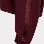 Maroon jogger pants with a patterned side stripe and elastic cuffs around the ankle.