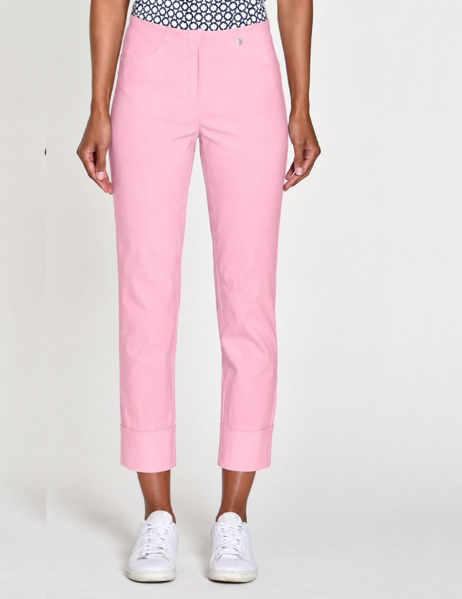 pink bella cuff Light pink cropped trousers with wide cuffs worn by a model paired with white sneakers, full-length view.